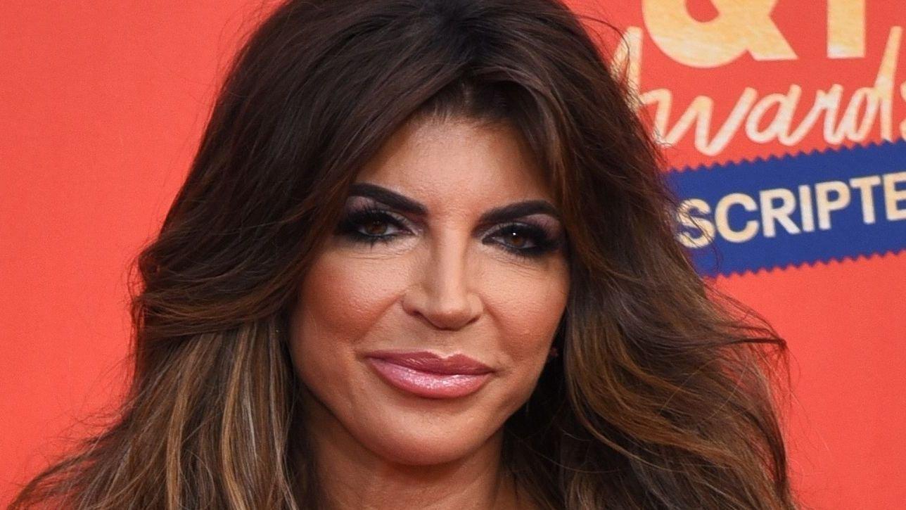 Teresa Giudice smiles with black dress and necklace