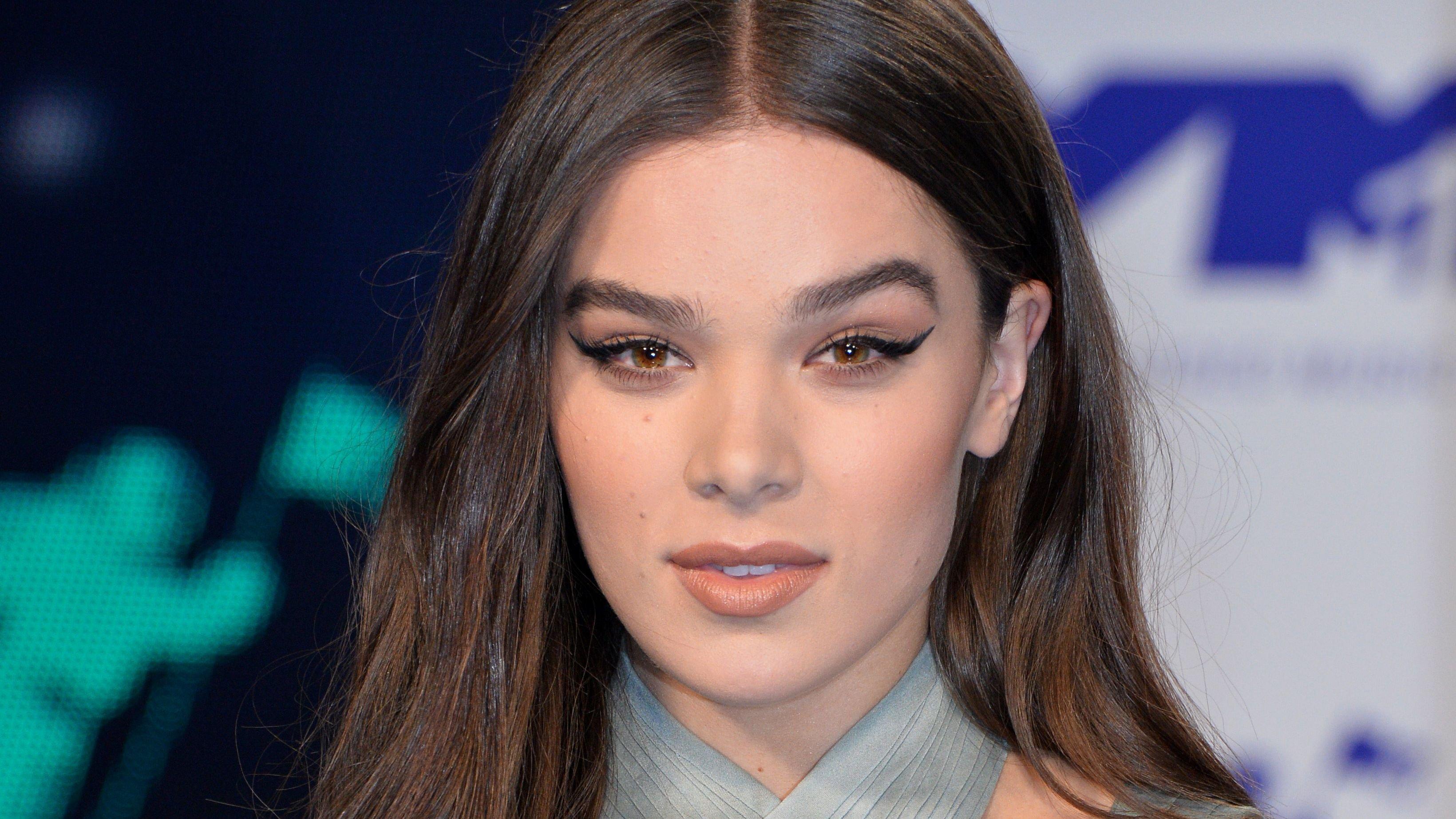 Hailee Steinfeld in strappy gray top with winged eyeliner.