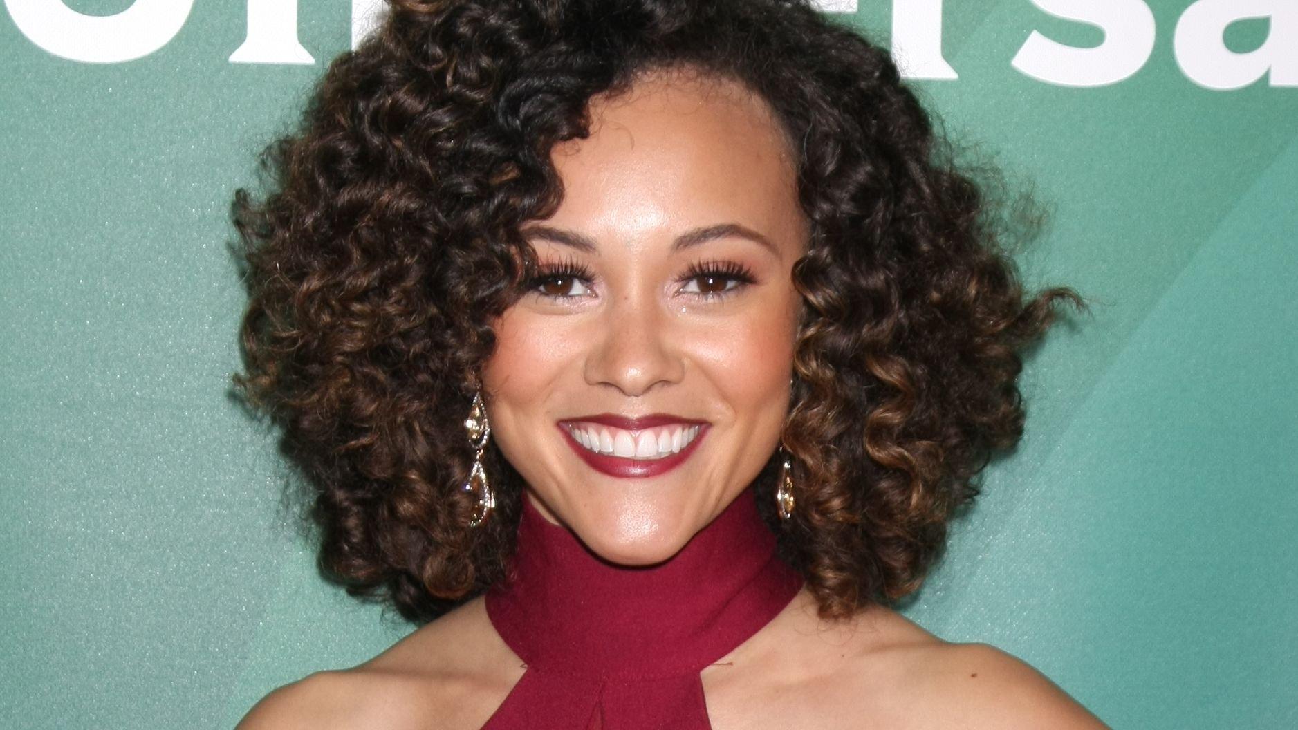 Ashley Darby smiles with short curly hair