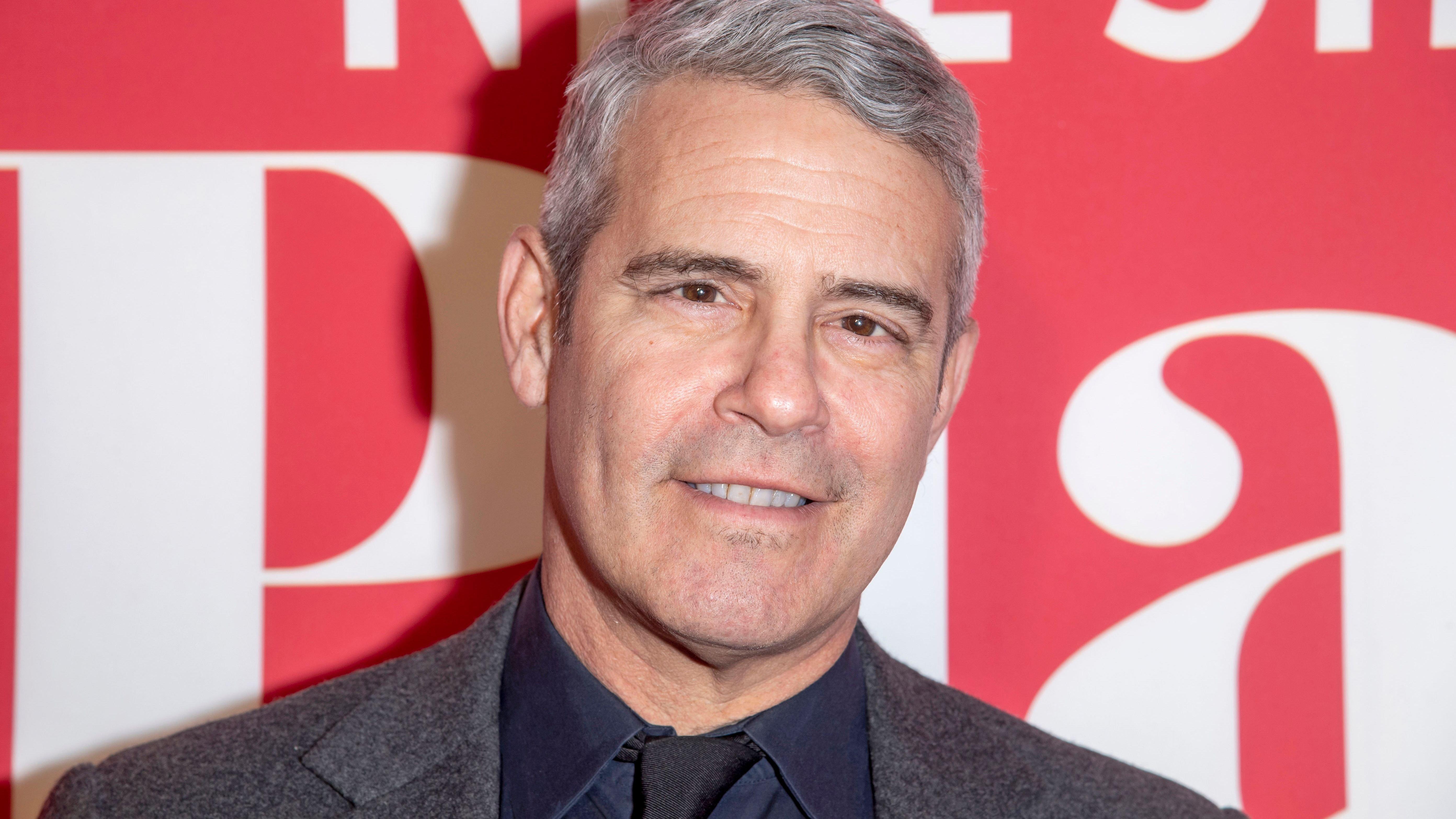 Andy Cohen wears gray suit and button-down