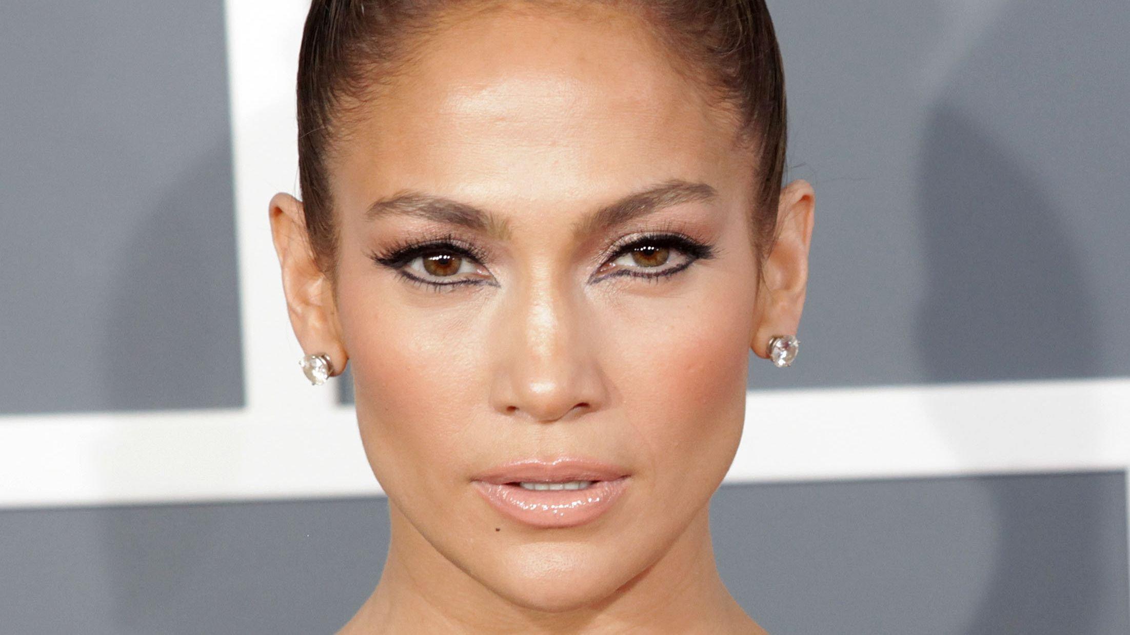 Jennifer Lopez rocks dramatic eyeliner, stud earrings, and slicked-back hair on the red carpet.